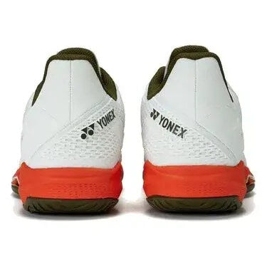 vista lateral de zapatillas yonex blancas con refuerzo naranja